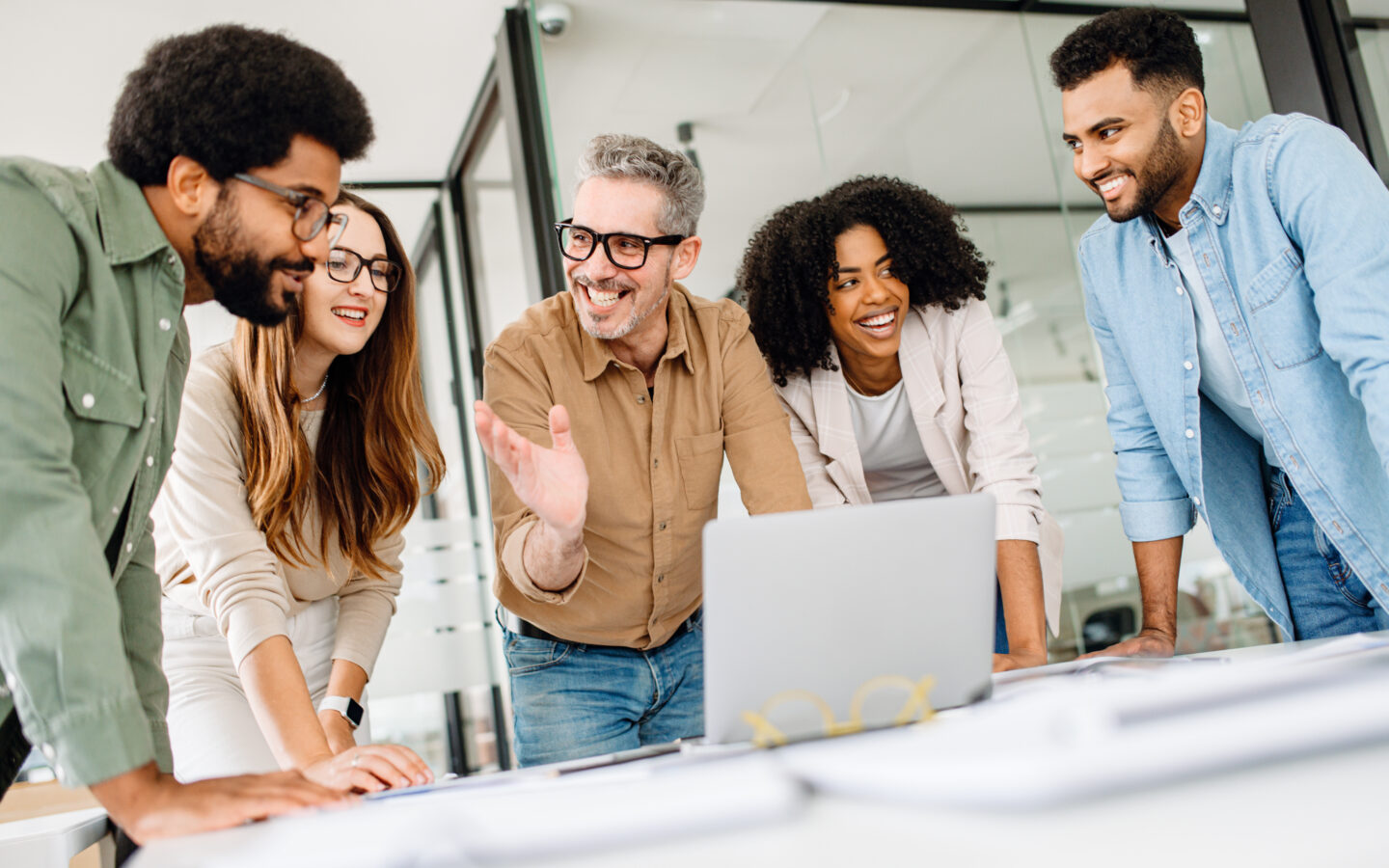 Confident business team working on a strategy at a desk, analyzing financial reports and discussing company growth. A diverse team in a corporate setting collaborating for success and innovatio