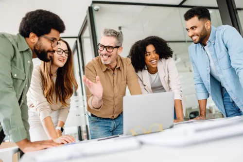 Confident business team working on a strategy at a desk, analyzing financial reports and discussing company growth. A diverse team in a corporate setting collaborating for success and innovatio
